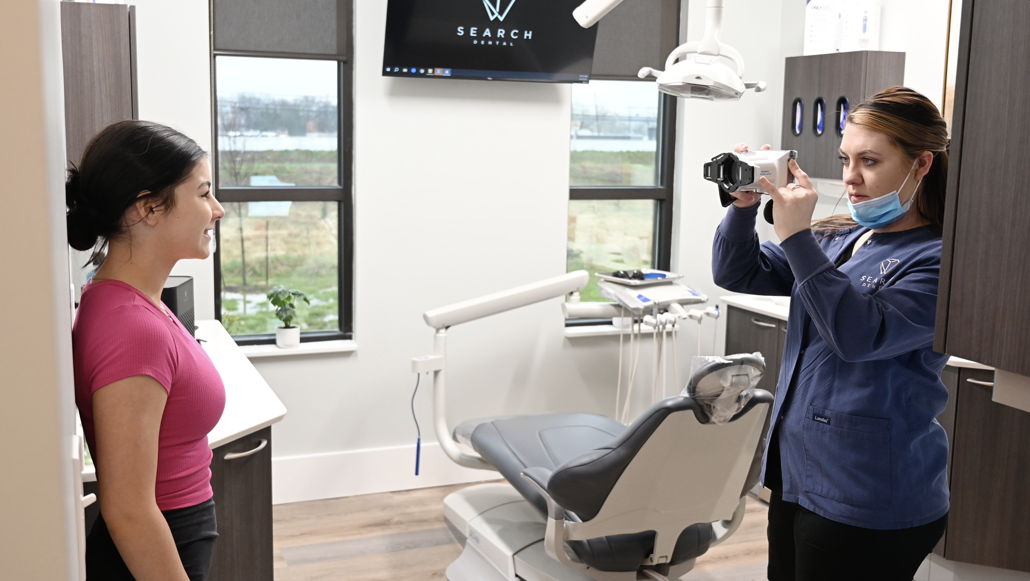 Orthodontic Assistant taking photos of young patient smiling for progress pictures